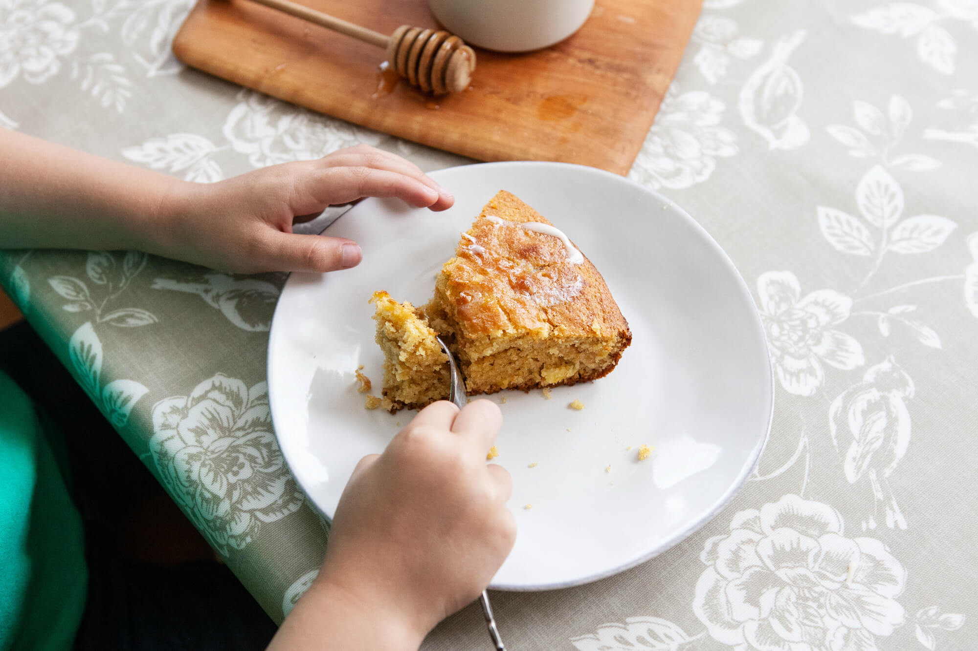 person slicing cornbread wedge made with Kate's Homemade Butter.