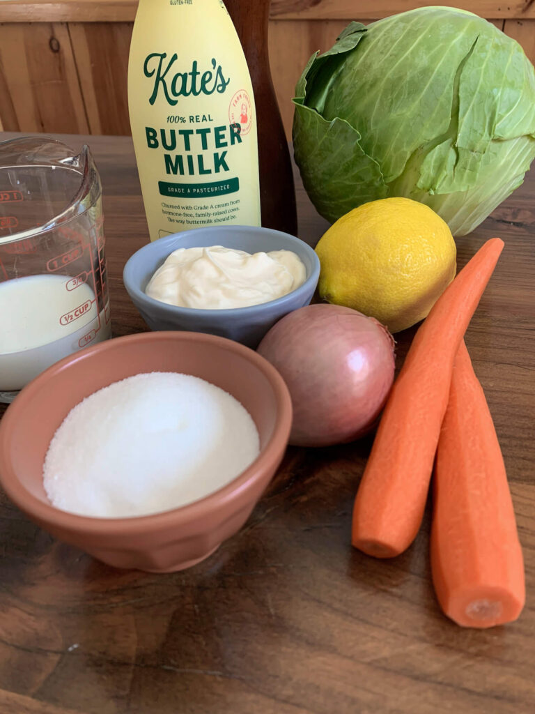 a bottle of kate's buttermilk, some vegetables, mayonnaise, and a bowl of sugar