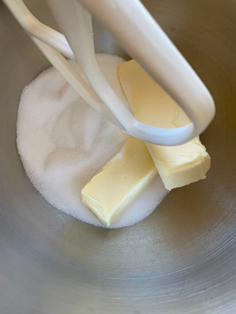 two sticks of butter and sugar in a mixing bowl