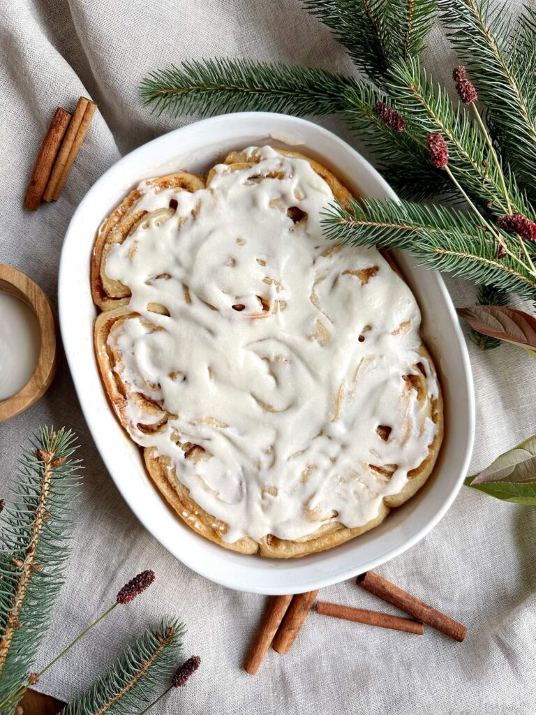 Serving dish full of Cinnamon rolls covered in icing