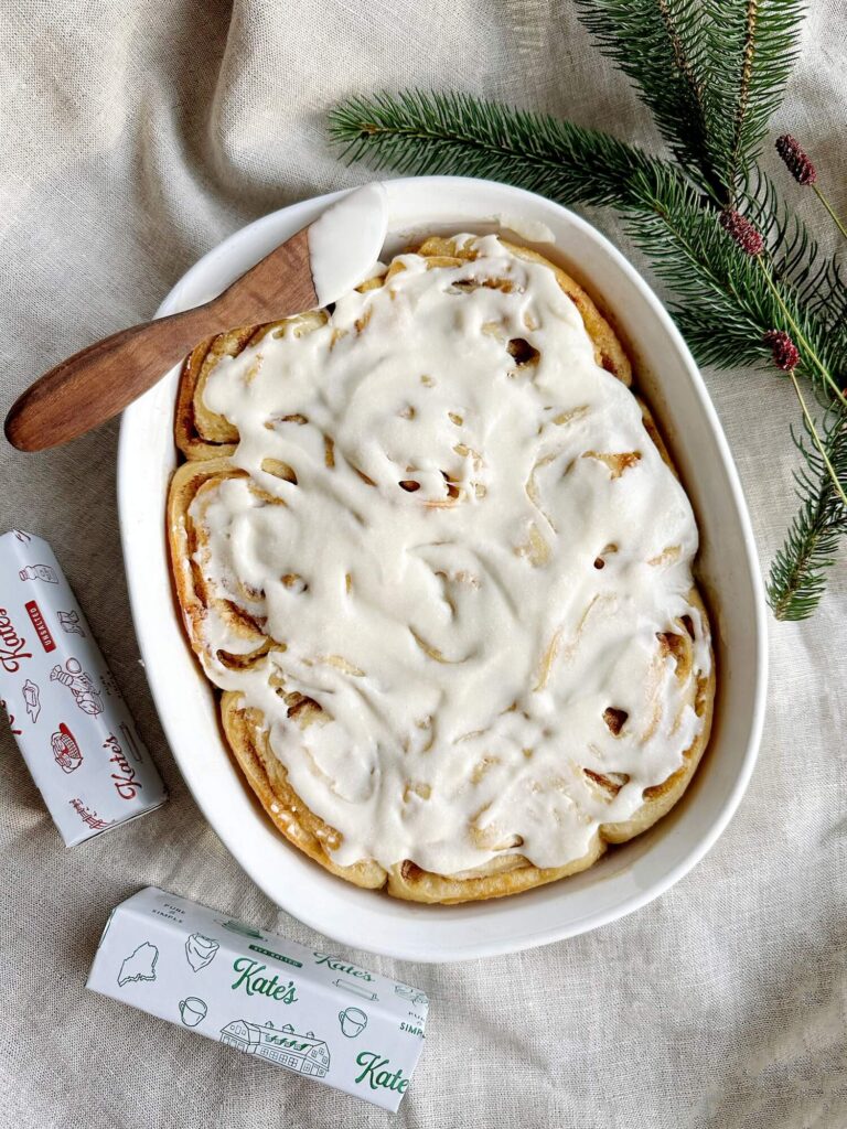 Serving dish full of Cinnamon rolls covered in icing