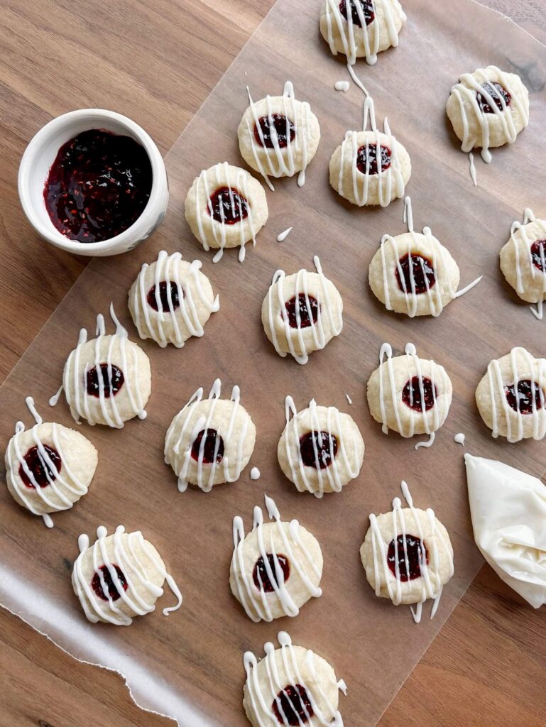 Raspberry thumbprint cooking laid out on a wooden table